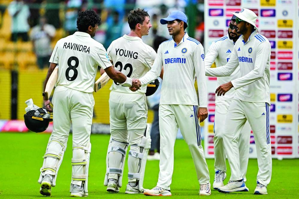 New Zealand’s Rachin Ravindra (left) and Will Young (second left) are congratulated by Indian players after their team’s win at the end of the first Test at the M Chinnaswamy Stadium of Bengaluru yesterday. (AFP)