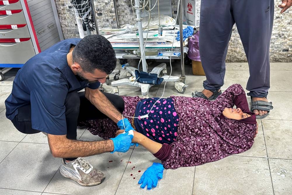 A Palestinian woman wounded in Israeli fire lies on the floor as she receives treatment at Kamal Adwan hospital in Jabalia, in the northern Gaza Strip, on Monday. REUTERS