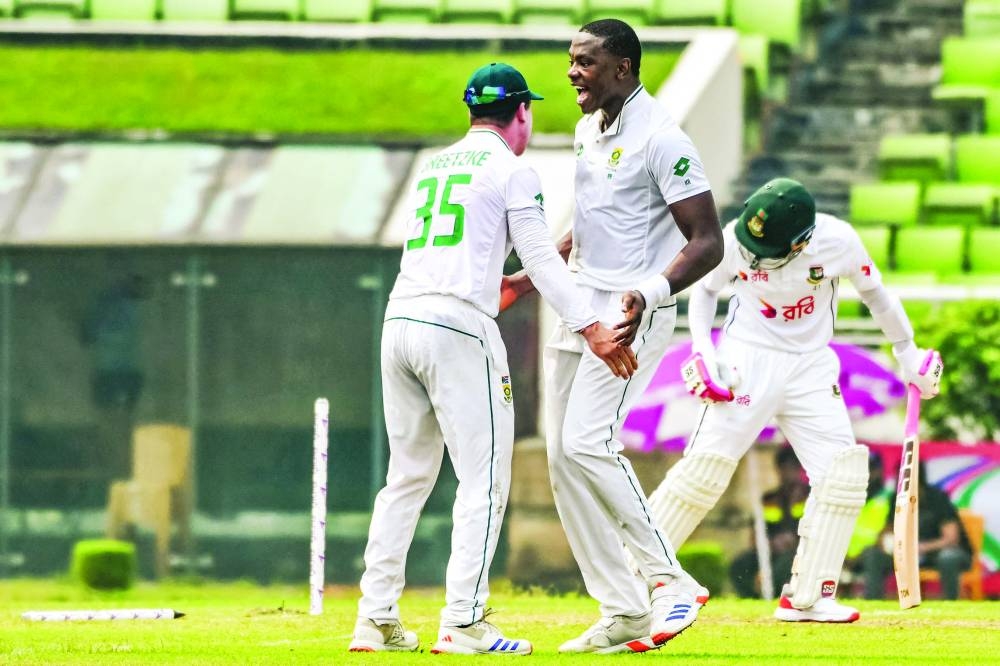 South Africa’s Kagiso Rabada (centre) celebrates with teammate after taking the wicket of Bangladesh’s Mushfiqur Rahim (right) during the first day of the first Test at the Sher-e-Bangla National Cricket Stadium in Mirpur, Dhaka, yesterday. (AFP)