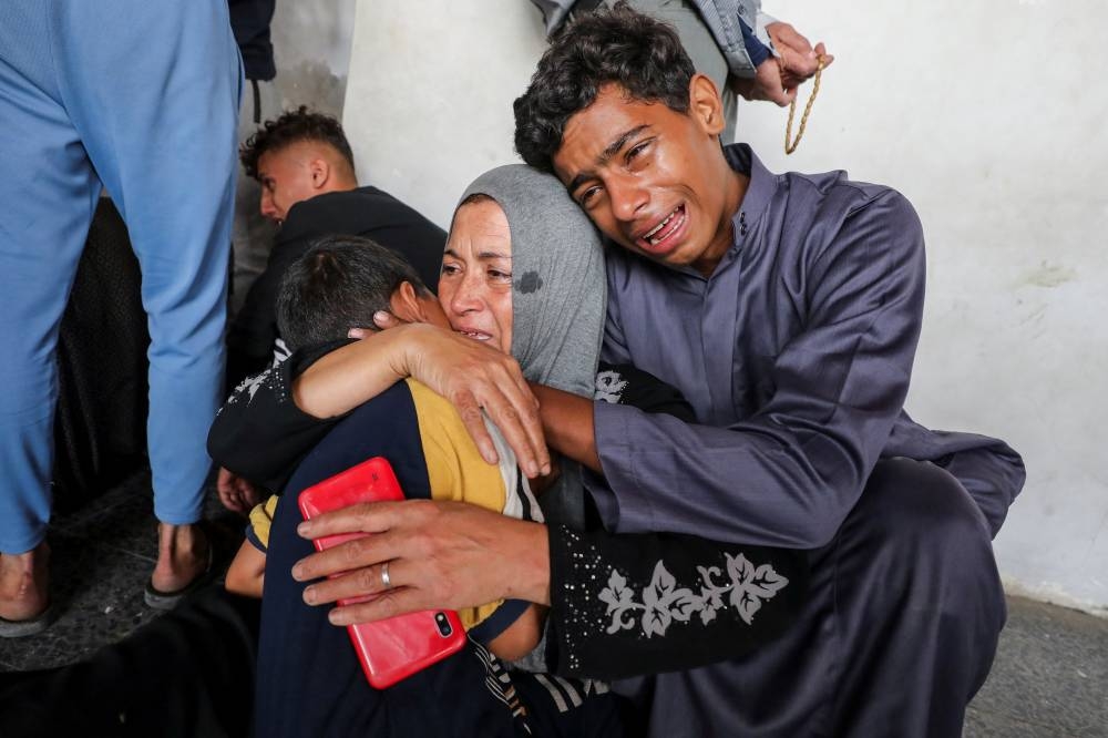The mother and children of Palestinian Ahmed Shnewra, who died of wounds sustained in an Israeli strike on, react at a hospital, in Gaza City, on Tuesday. REUTERS