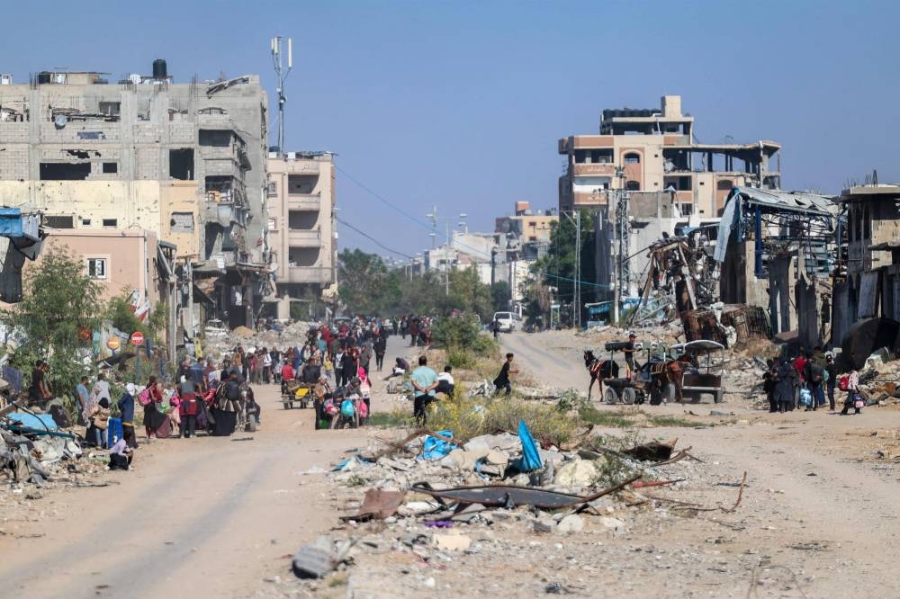 Displaced Palestinians fleeing Israeli military operations in Beit Lahia in the northern Gaza strip walk along the Salah al-Din main road in eastern Gaza City making their way to the city centre, on Tuesday. AFP