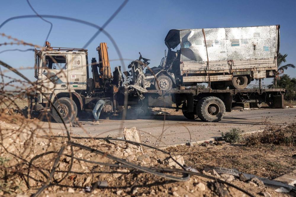 A destroyed truck that was reportedly used by workers of the United Nations Relief and Works Agency for Palestine Refugees (UNRWA), which was fired upon by Israeli forces earlier, is loaded onto the back of a trailer along Gaza's main Salah al-Din road outside Deir el-Balah in the centre of the Gaza Strip on Wednesday. AFP