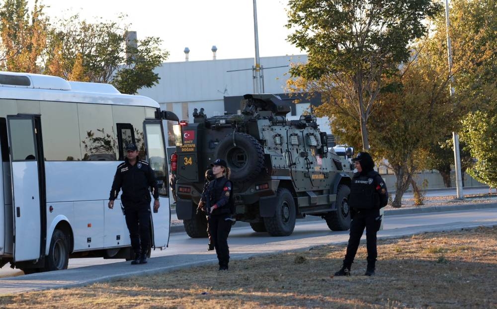 Turkish police officers gather as an armed personnel vehicle drives along a road in Kahramankazan on Wednesday, near the gate of the Turkish Aerospace Industries (TAI), after a huge explosion outside the headquarters. AFP