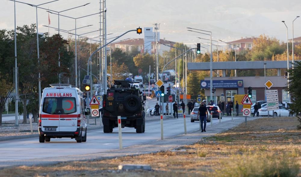 An armoured personnel vehicle and an ambiulance move along a road in Kahramankazan on Wednesday, near the gate of the Turkish Aerospace Industries (TAI), after the explosion outside the headquarters. AFP