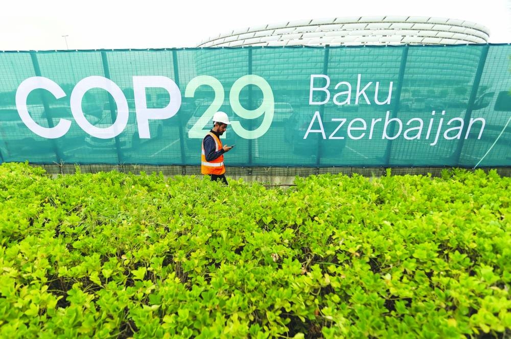 A worker walks along a fence near the Baku Olympic Stadium, the venue of the COP29 United Nations Climate Change Conference, in Baku, Azerbaijan. – Reuters