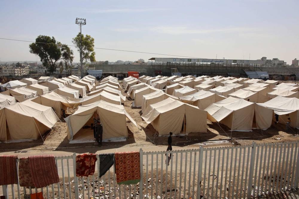 Displaced Palestinians who fled Israeli army operations in the northern Gaza Strip, set up tents to be used as temporary shelters at the Yarmouk Sports Stadium, once a football arena, in Gaza City on Friday. AFP