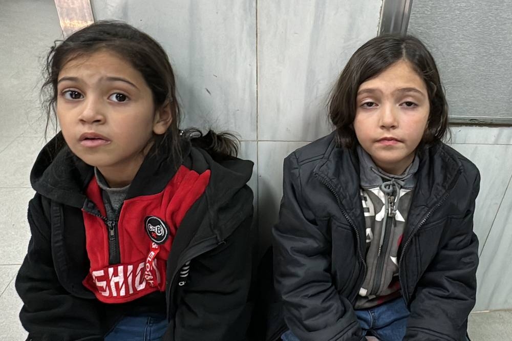 Girls look on as they sit on the floor of the trauma ward of the Kamal Adwan Hospital in Beit Lahia the northern Gaza Strip on Thursday. AFP