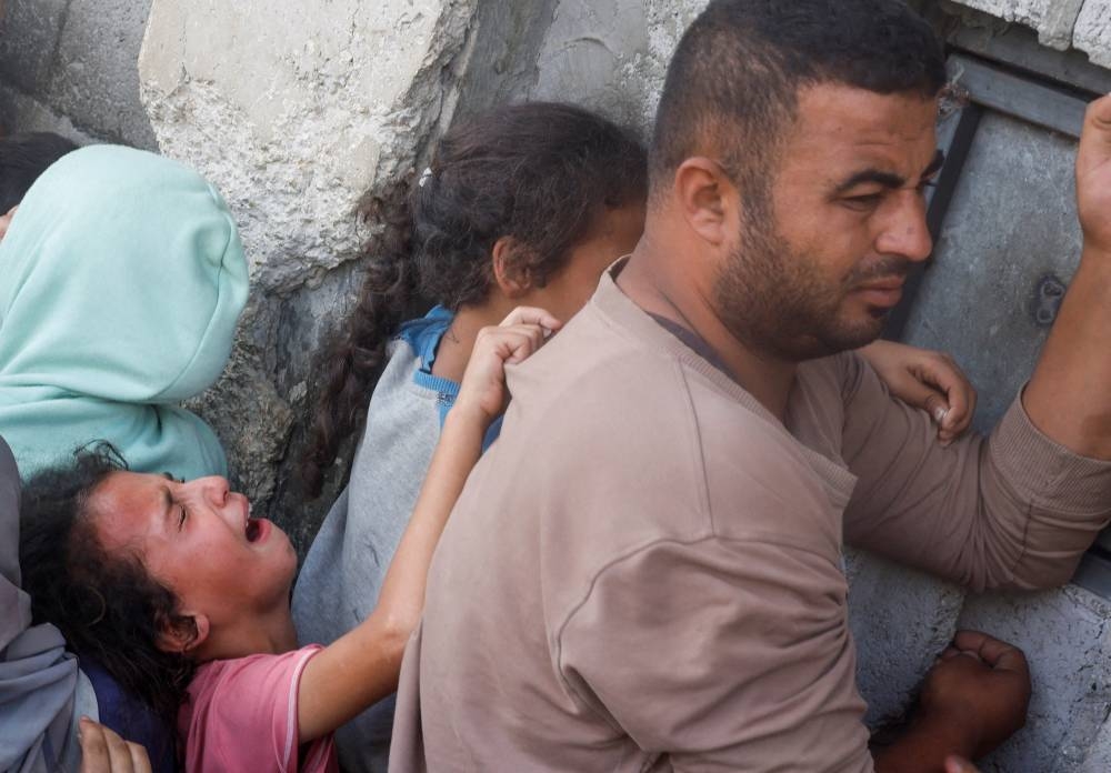 A girl reacts as Palestinians gather to buy bread from a bakery, amid the Israel-Hamas conflict, in Khan Younis, southern Gaza Strip on Wednesday. REUTERS