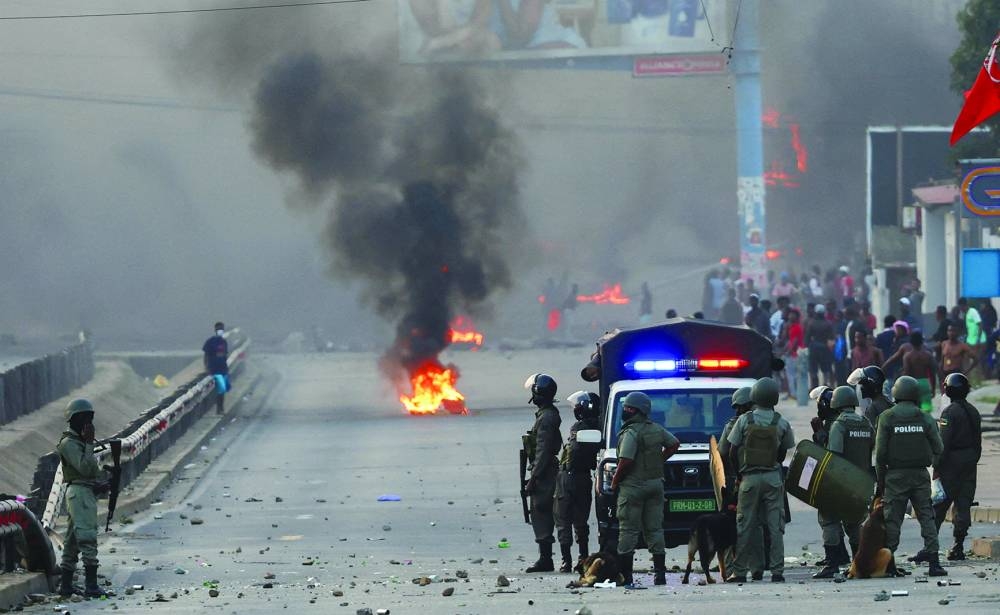 Riot police look on as protesters burn tyres after Mozambique's ruling party, FRELIMO, retains power in contested election in Maputo, Mozambique.