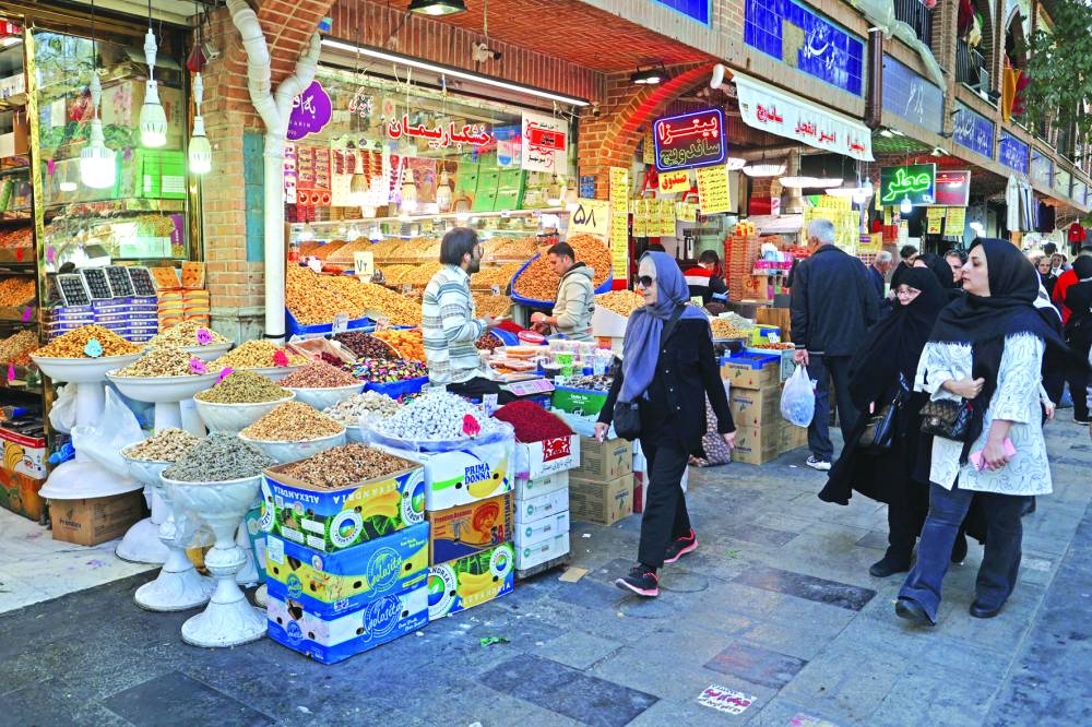 Iranians walk in Tehran Bazaar after several explosions were heard, in the capital, yesterday.