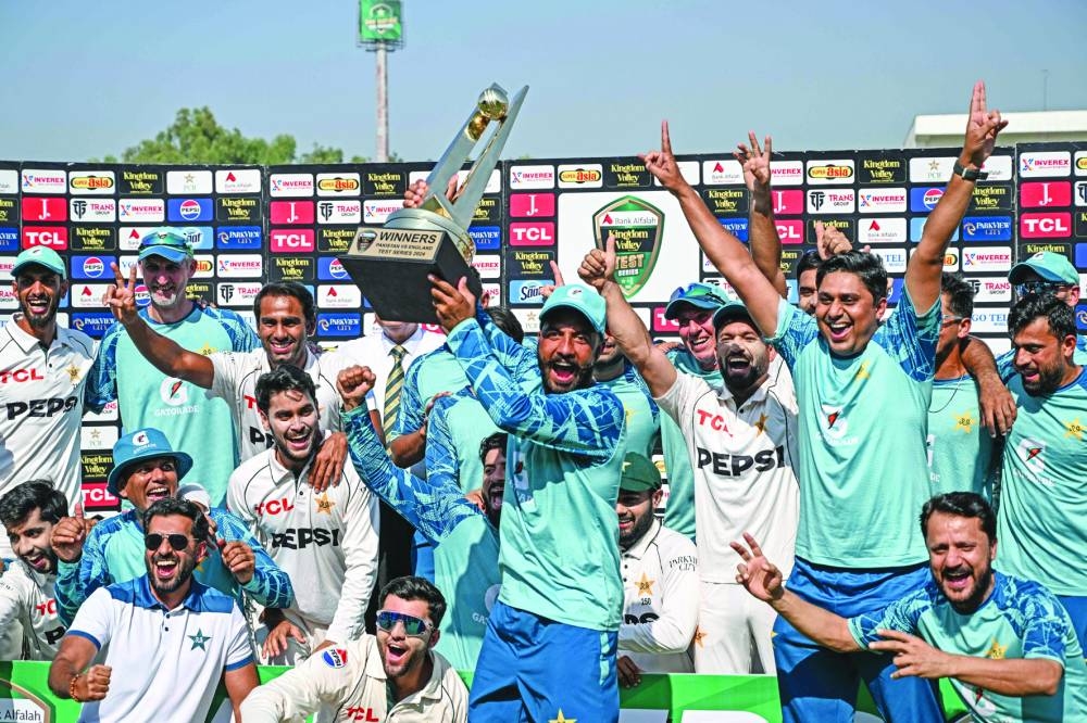 Pakistan’s players and team officials celebrate with the series trophy after winning the third and final Test against England at the Rawalpindi Cricket Stadium in Rawalpindi on Saturday. (AFP)