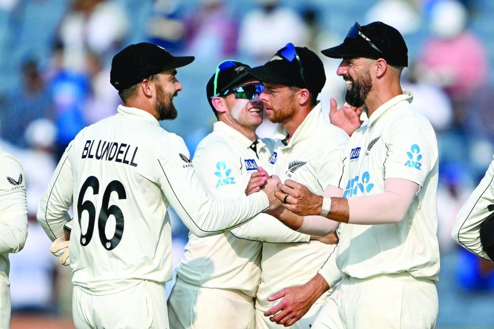 
New Zealand’s Tom Blundell (left), captain Tom Latham (second from left), Mitchell Santner (second from right) and Daryl Mitchell celebrate after their win against India on the third day of second Test in Pune yesterday. (AFP) 