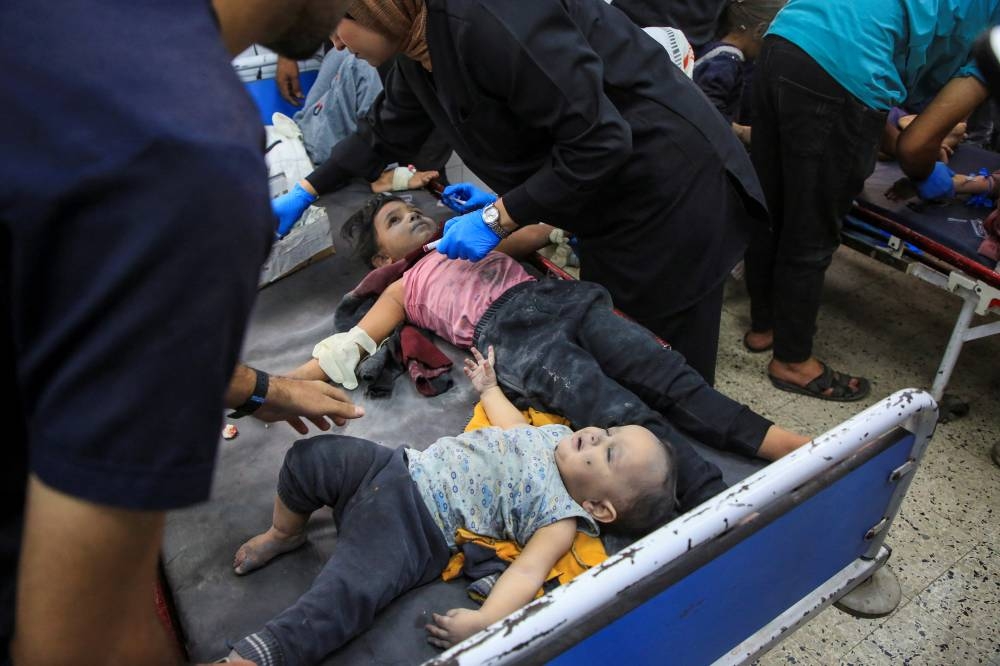 Palestinian children wounded in an Israeli strike receive treatment at Al-Ahli hospital in Gaza City, Saturday. REUTERS