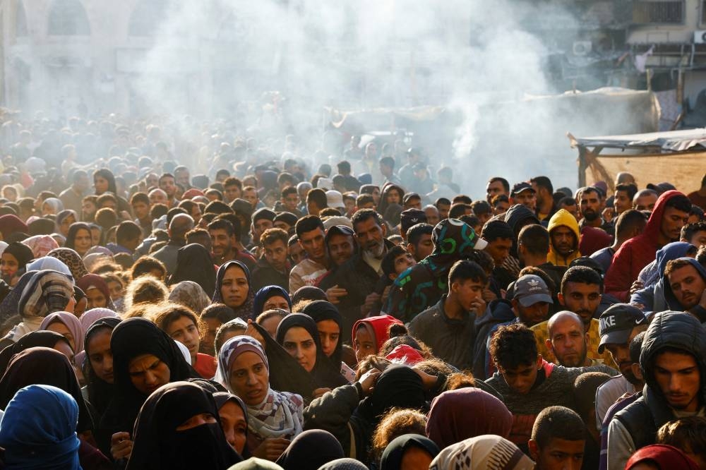 Palestinians gather to buy bread from a bakery, amid the Israel-Hamas conflict, in Khan Younis, in the southern Gaza Strip on Monday. REUTERS