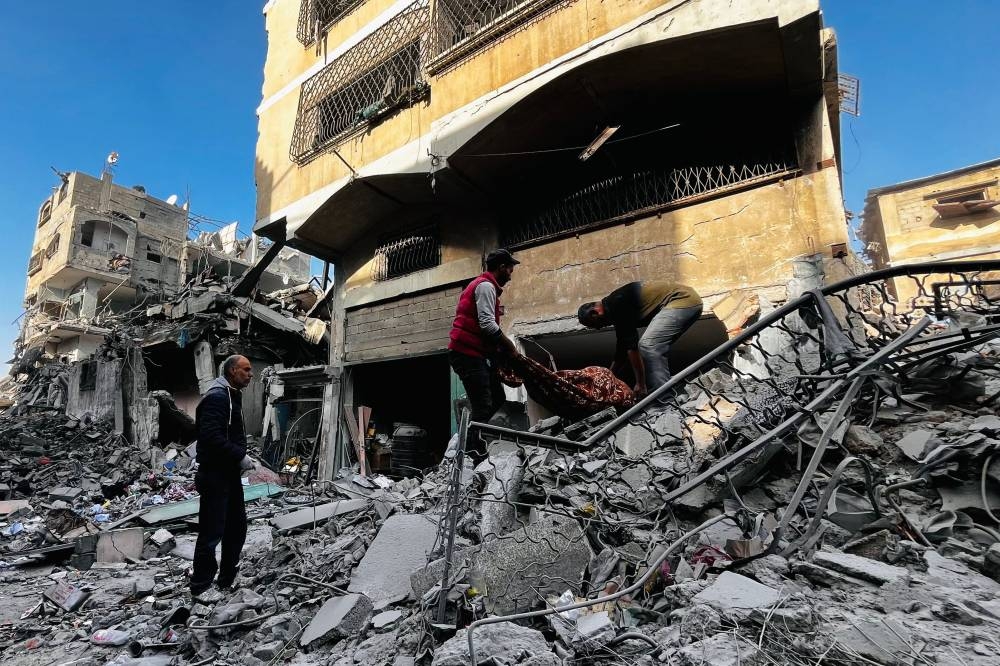 Palestinian remove a body from the rubble of a building hit by an Israeli strike in Beit Lahia, in the northern Gaza Strip, on Tuesday. AFP