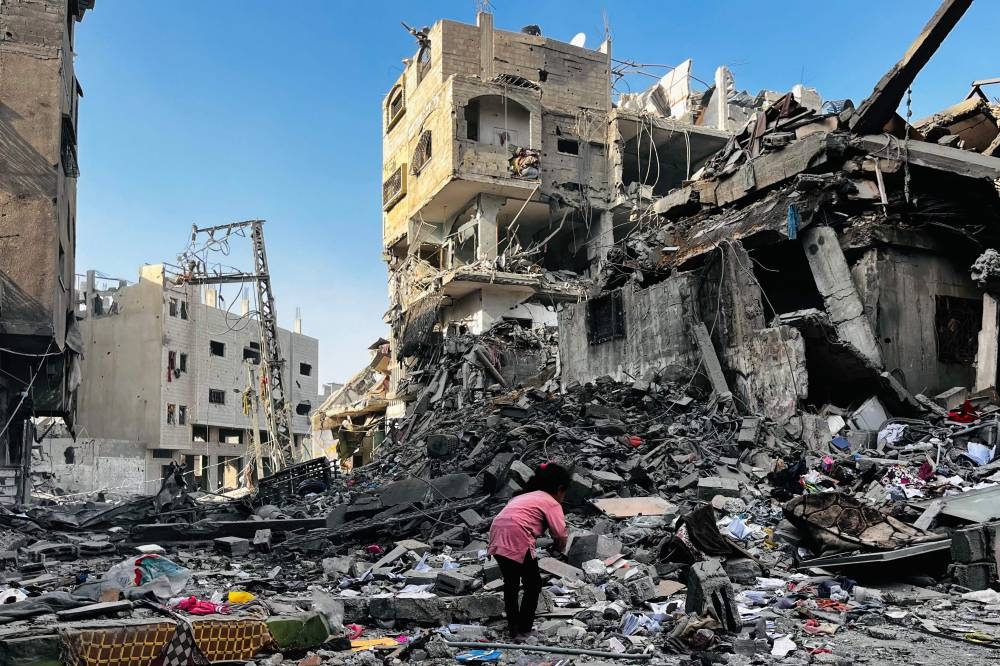 A Palestinian girl inspects the rubble of a building after an Israeli strike in Beit Lahia, in the northern Gaza Strip, on Tuesday. AFP