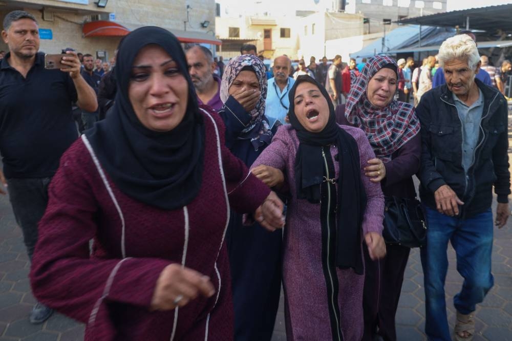Family members mourn the death of Palestinian children Nayef and Abdallah Nashwan, who were killed in Israeli bombardment of al-Zawaydeh village in the central Gaza Strip where the family sought shelter after displacement from al-Bureij camp, at the Al-Aqsa Martyrs Hospital in Deir el-Balah on Tuesday. AFP