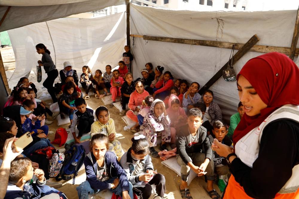 Palestinian children attend a session as part of a campaign organized by the International Committee of the Red Cross (ICRC) in cooperation with the Palestinian Red Crescent Society, aimed at raising awareness about the dangers of unexploded ordnance, in Khan Younis, southern Gaza Strip, on Wednesday. REUTERS