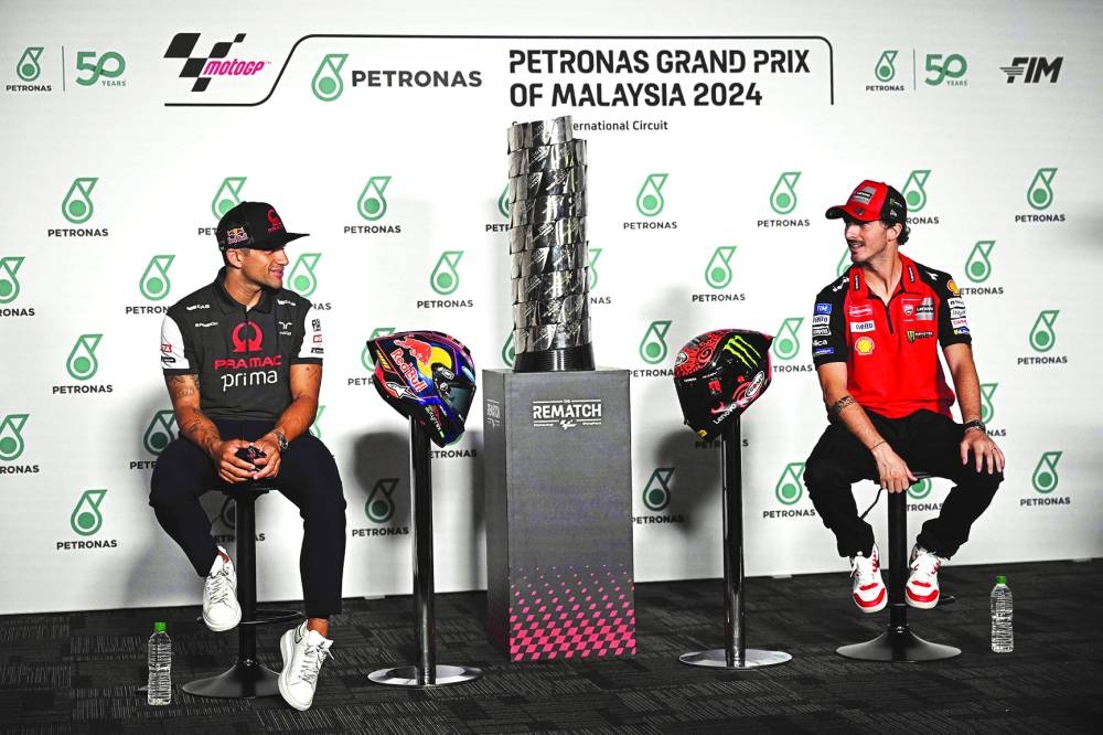 Prima Pramac Racing’s Spanish rider Jorge Martin (left) and Ducati Lenovo Team’s Italian rider Francesco Bagnaia interact during a press conference held before the Malaysian Grand Prix at the Sepang International Circuit yesterday. (AFP)