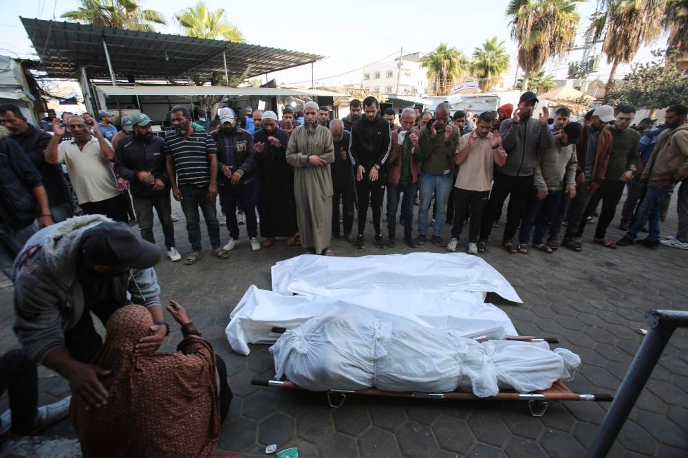 A woman reacts as others recite a prayer over the bodies of victims killed an Israeli strike on the Nuseirat refugee camp, in front of the al-Aqsa Martyrs hospital in Deir el-Balah in the central Gaza Strip, on Friday. AFP