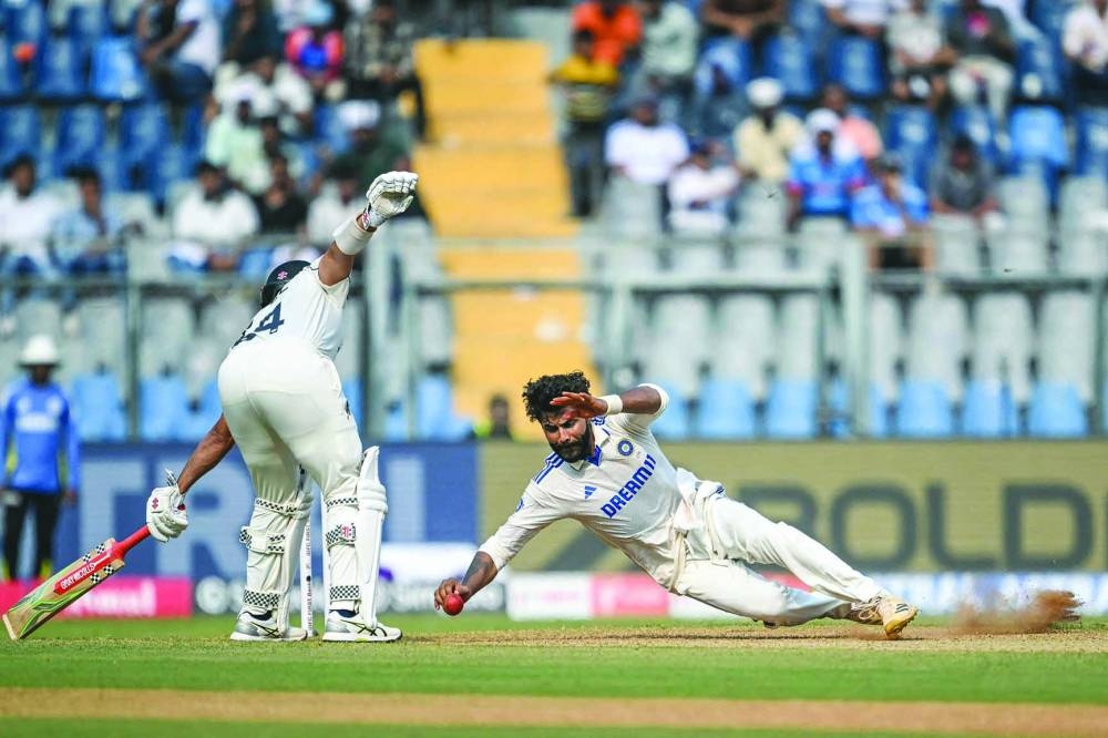 
India’s Ravindra Jadeja (right) dives to field the ball during the first day of the third Test against New Zealand at the Wankhede Stadium in Mumbai yesterday. (AFP) 
