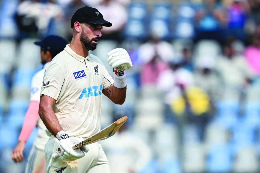 
New Zealand’s Daryl Mitchell celebrates after scoring a half-century during the first day of the third Test against India in Mumbai. (AFP) 