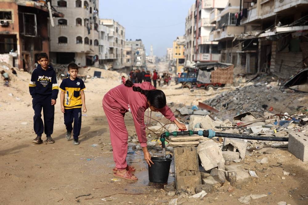 A Palestinian girl fills a bucket with clean water in Gaza City on Saturday. AFP