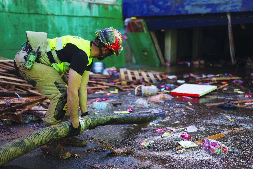 A member of Spain’s Military Emergency Unit works on removing water from one of the exits of the Bonaire shopping centre car park near Valencia yesterday. (Reuters)