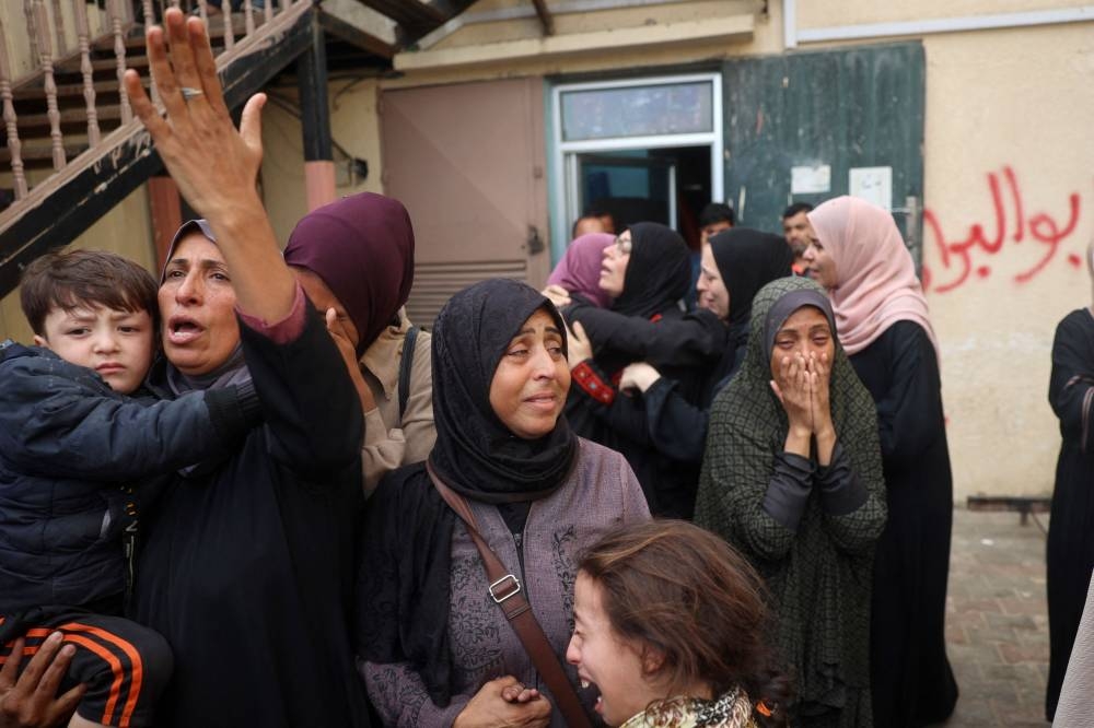 Relatives of Mahmoud Foura, and his son Saad Foura, who were killed during overnight Israeli bombardment, mourn at Al-Aqsa Martyrs hospital in Deir el-Balah in the central Gaza Strip on Sunday. AFP