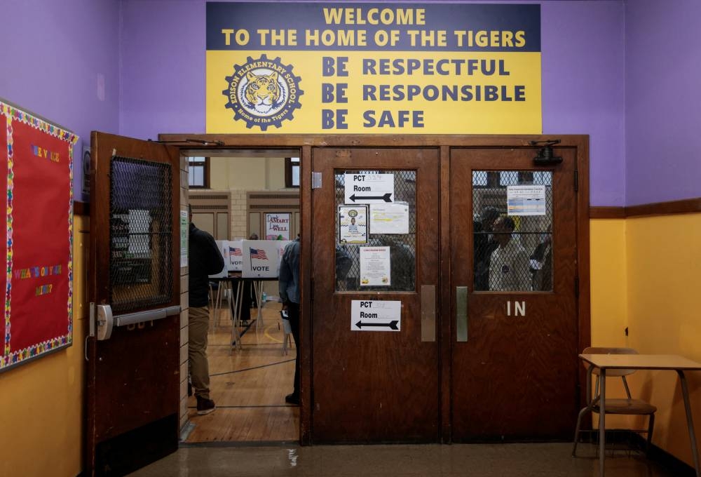 People stand in a polling station in the 2024 US presidential election on Election Day in Detroit, Michigan, on Tuesday. REUTERS
