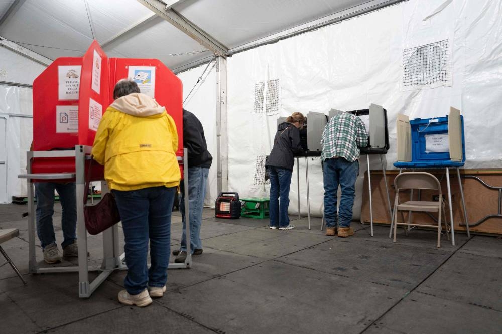 People vote in the US presidential election in a voting tent on the day of the US presidential election, on Tuesday in Burnsville, North Carolina. AFP