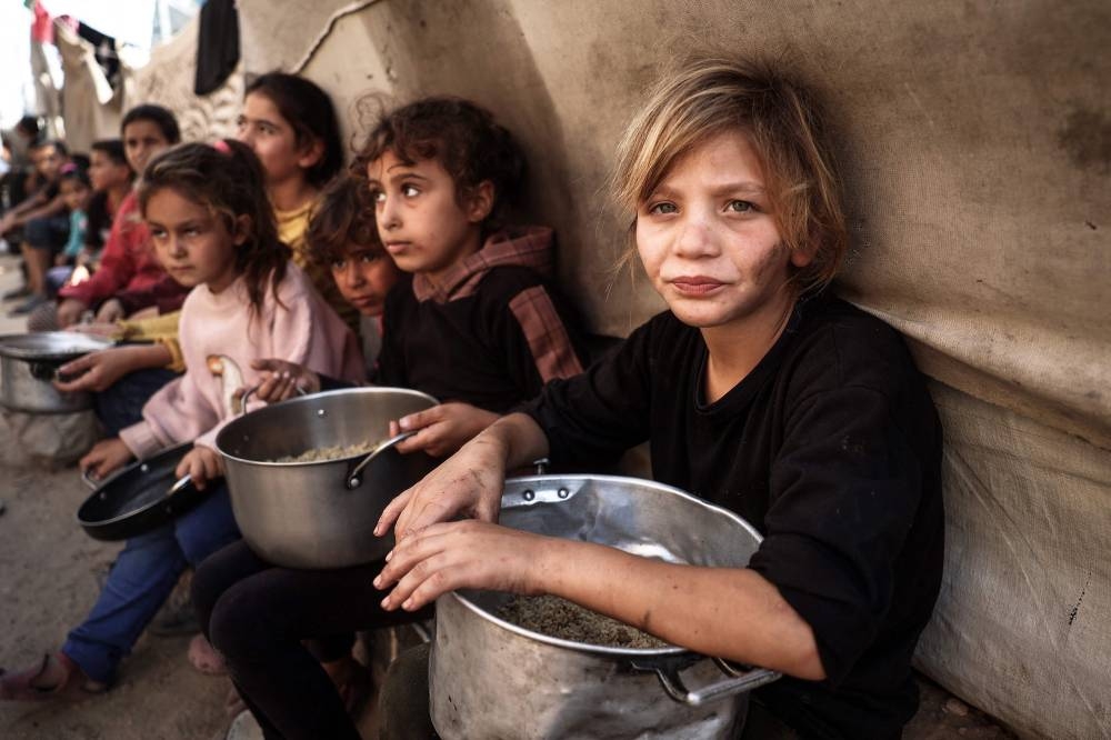 Palestinian children collect aid food at Bureij refugee camp in the central Gaza Strip, on Wednesday. AFP