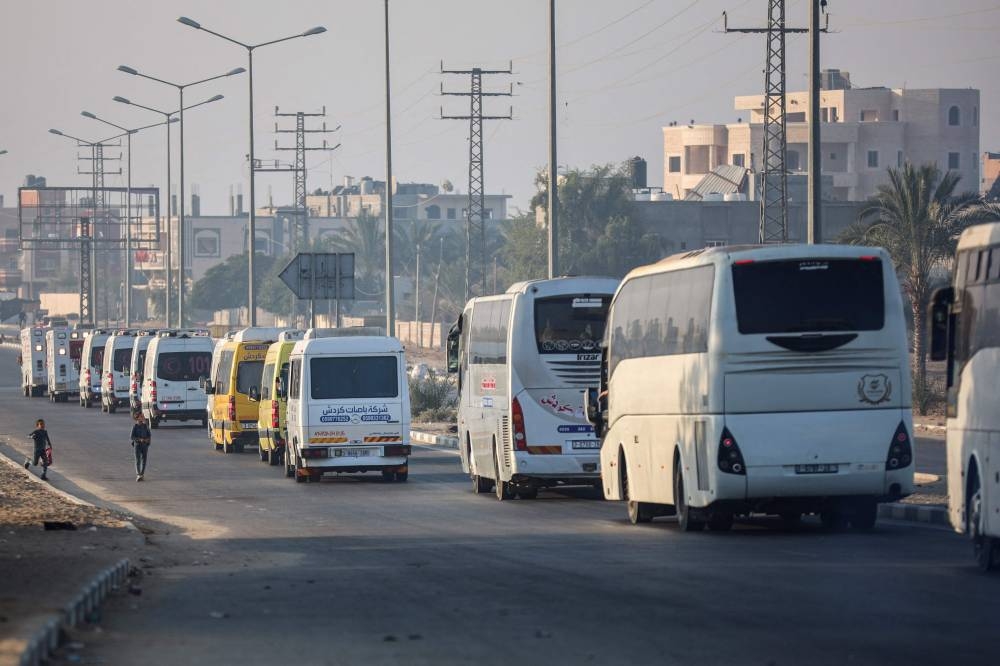 Children watch a convoy of the World Health Organization and the Palestinian Red Crescent moving from the European Hospital in Khan Yunis south of Gaza, evacuating patients and war-wounded from the besieged Palestinian territory to several Arab and other countries on Wednesday. AFP