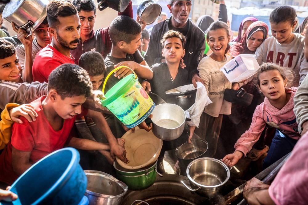 Palestinians collect aid food at Bureij refugee camp in the central Gaza Strip,  on Wednesday. AFP