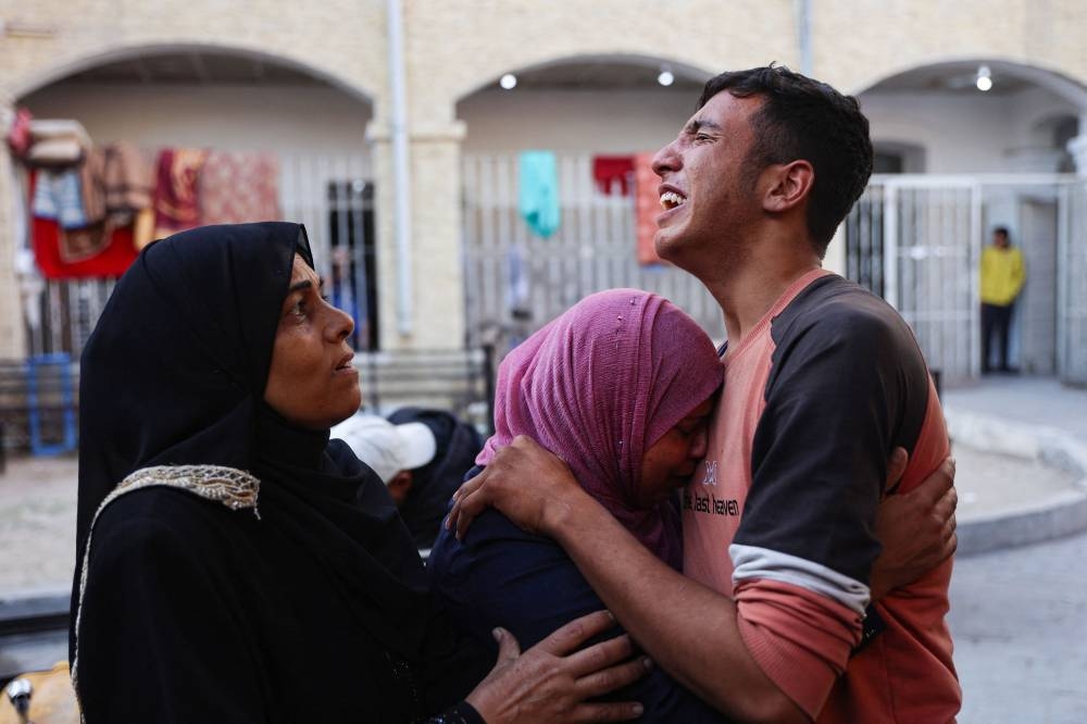 Relatives mourn the death of Atef Al-Atout, a Palestinian man who his family said was shot dead as he fled Beit Lahia in the northern Gaza Strip toward in Gaza City,  in front of the al-Maamadani hospital on Wednesday. AFP