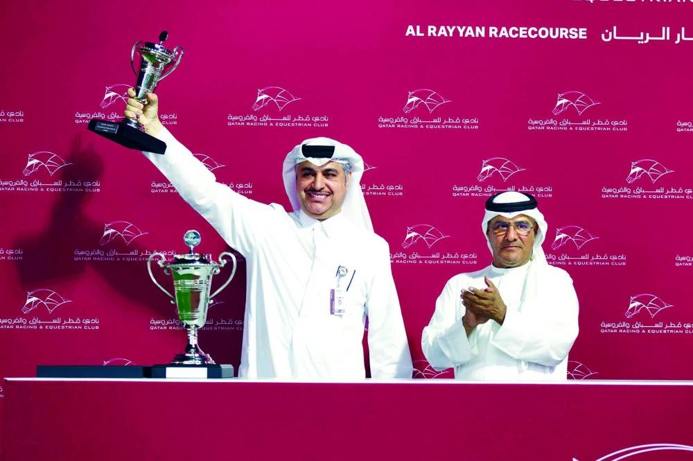 
Mared Al Jasra’s trainer Jassim Ghazali (left) celebrates with Al Beshariyah Cup at the 
Al Rayyan Park yesterday. PICTURES: Juhaim 