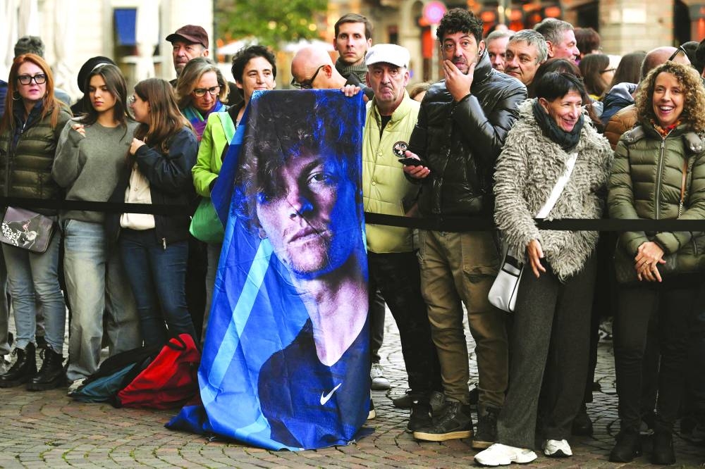 
Tennis fans hold a poster of Italy’s Jannik Sinner before the arrival of players at the ATP Finals blue carpet event at Piazza Carlo Alberto in Turin yesterday.  (AFP) 