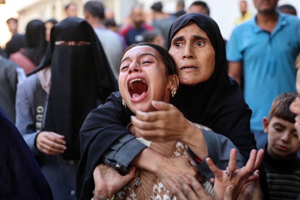 A young Palestinian girl reacts in the courtyard of the al-Shifa hospital in Gaza City after the bodies of victims were transported there, following an Israeli strike that hit a school-turned-shelter in the Al-Shati refugee camp on Thursday. AFP