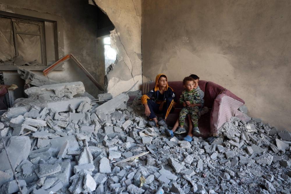 Children sit on a couch amid the destruction following an Israeli strike in the Nuseirat refugee camp in the central Gaza Strip on Thursday. AFP