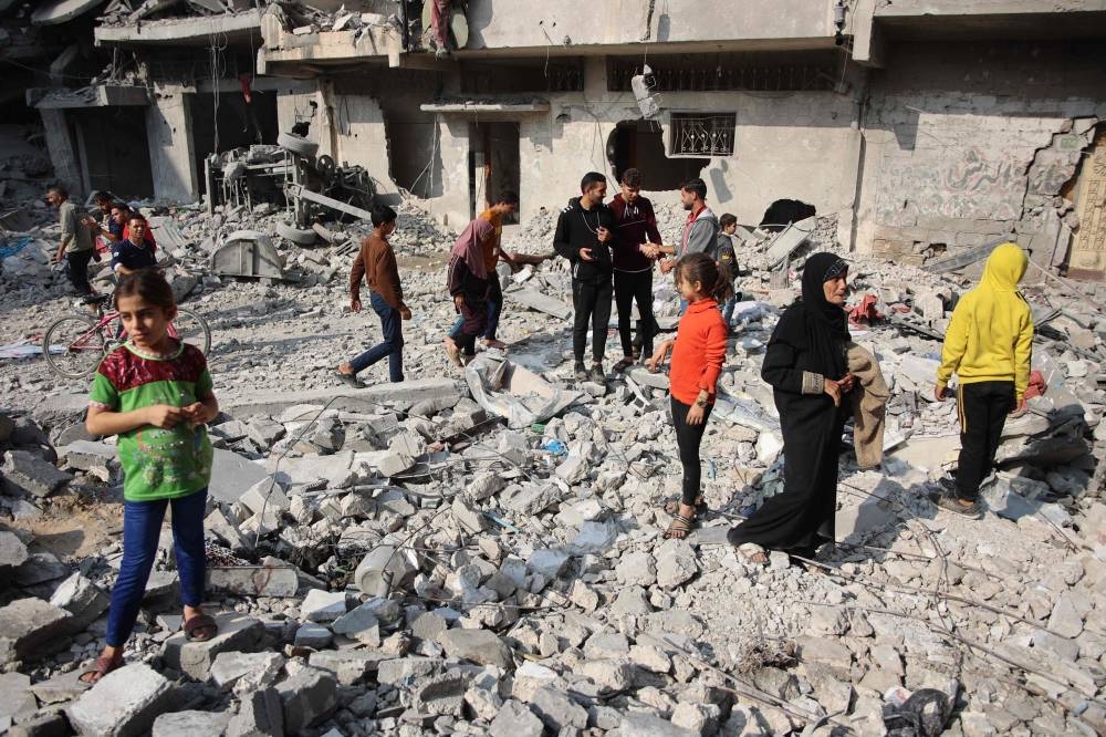 Palestinians walk amid the destruction following an Israeli strike in Jabalia in the northern Gaza Strip, on Sunday. AFP