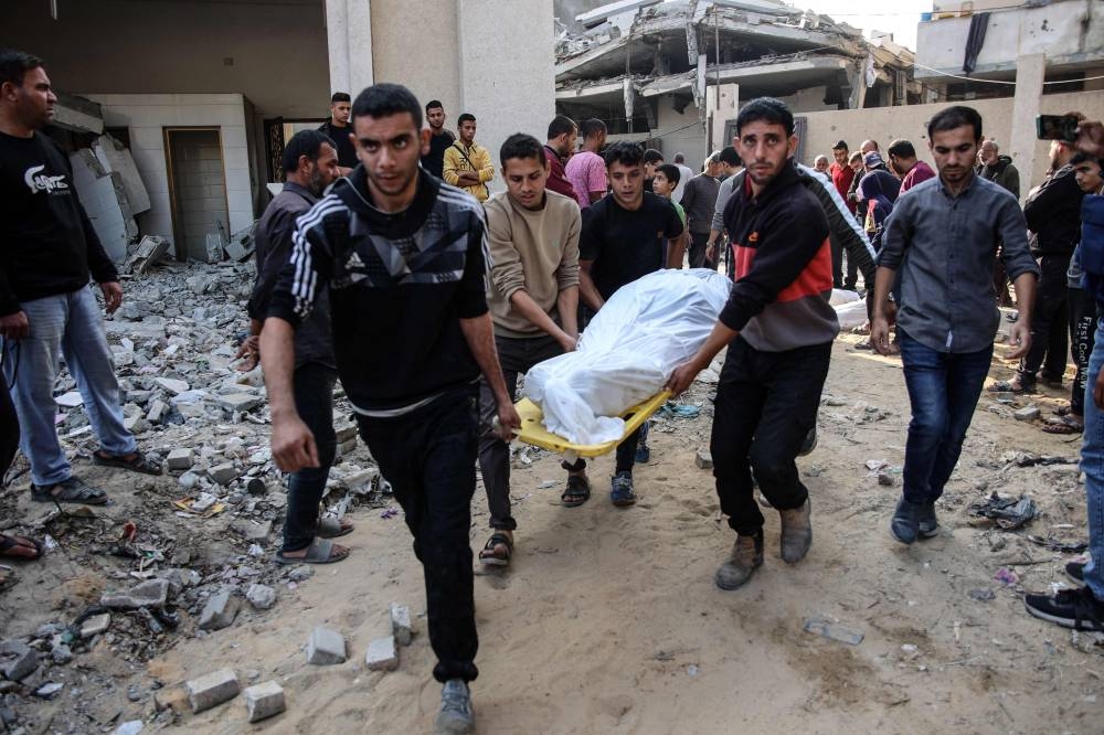 Palestinians carry the body of a victim killed in Israeli strikes toward a cemetery in Jabalia in the northern Gaza Strip, on Sunday. AFP