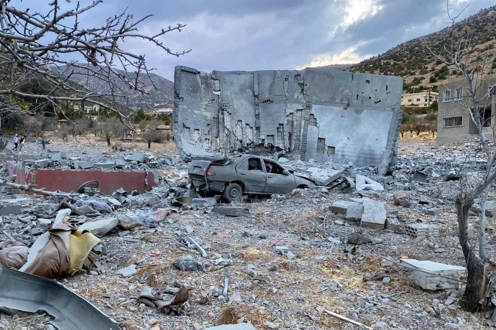 A damaged car is seen next to a destroyed building in the aftermath of an Israeli airstrike that targetted the eastern Lebanese village of Zeghrine in the Hermel area, on Sunday. AFP