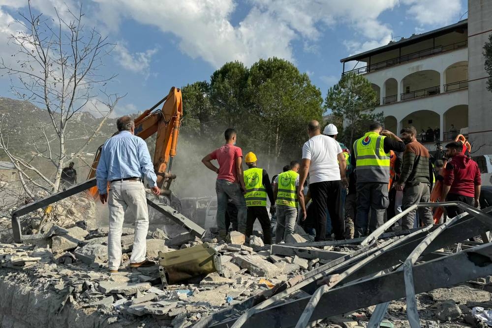 Rescuers use an excavator to search for survivors at the site of an Israeli airstrike that targeted the village of Almat north of Beirut, on Sunday. AFP
