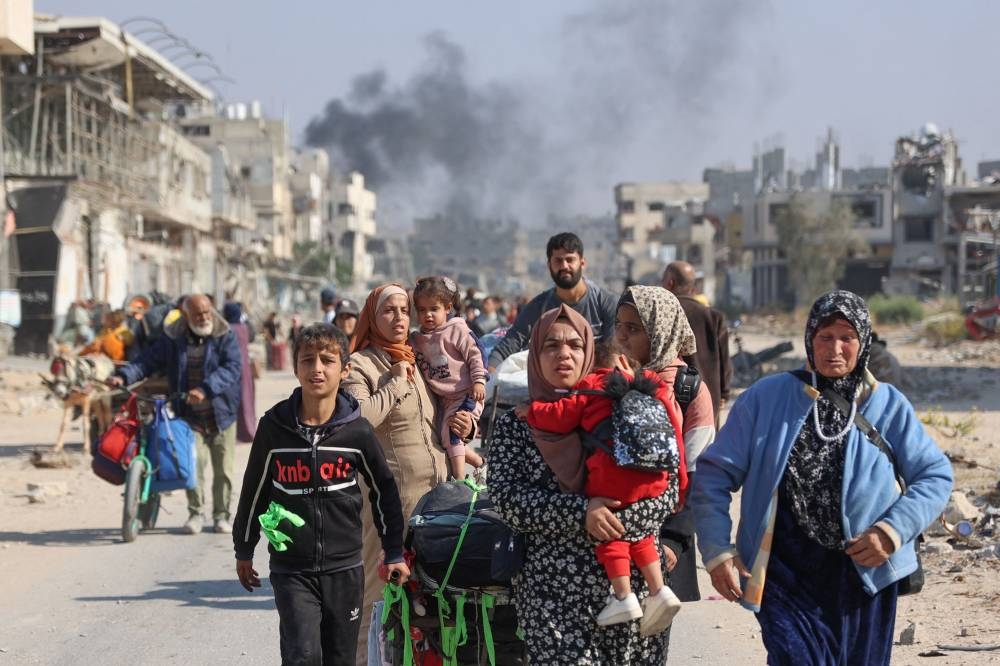 Palestinians displaced from shelters in Beit Hanoun cross the main Salaheddine road into Jabalia in the northern Gaza Strip following Israeli army evacuation orders, on Wednesday. AFP