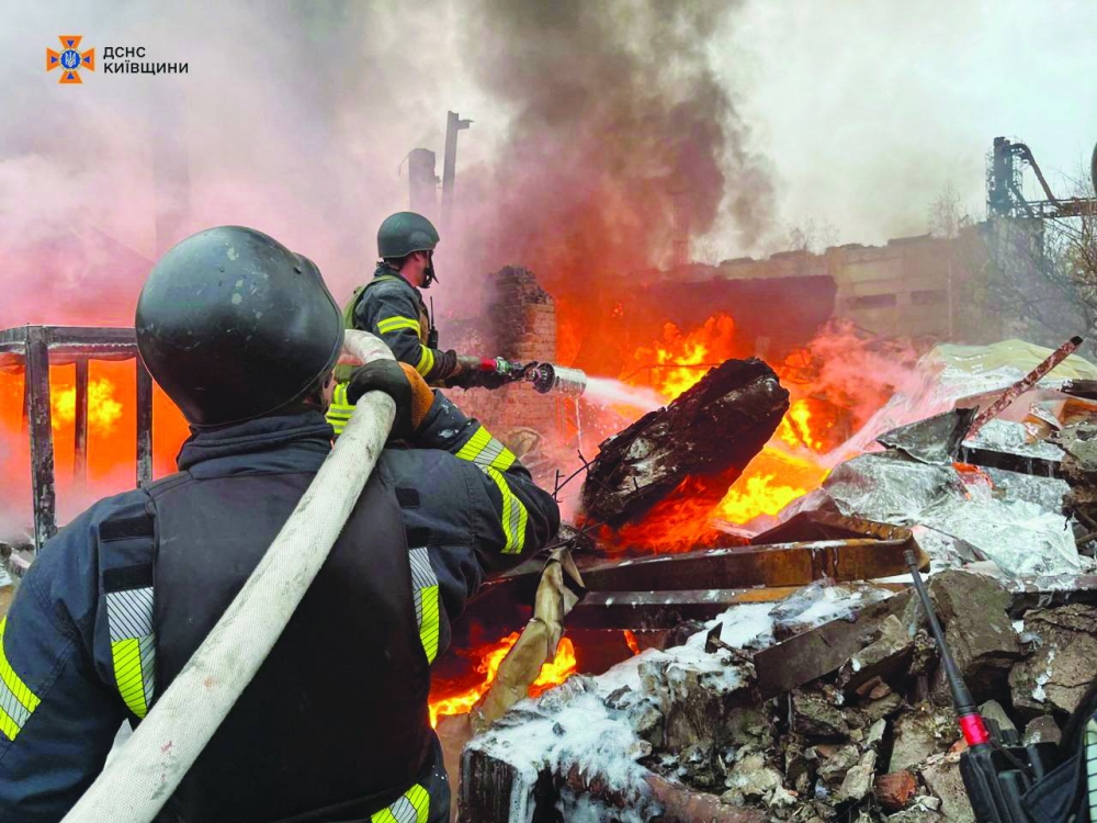 Firefighters work at the site where an industrial area was hit by a Russian missile strike in Kyiv region yesterday. (Reuters)