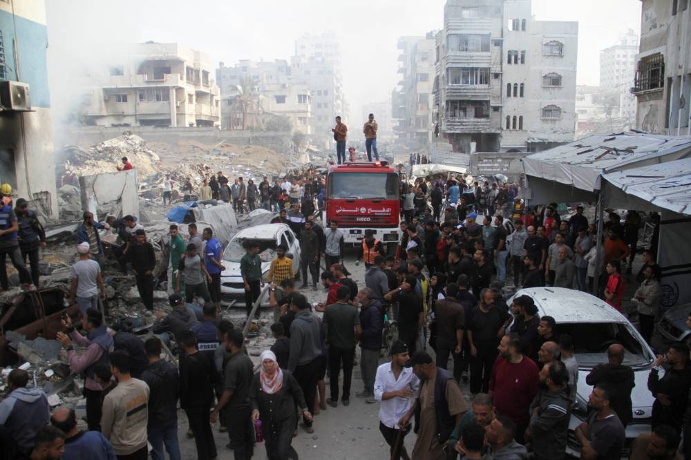Palestinians inspect the damage at a school sheltering displaced people, after it was hit by an Israeli strike, in Gaza City on Thursday. REUTERS