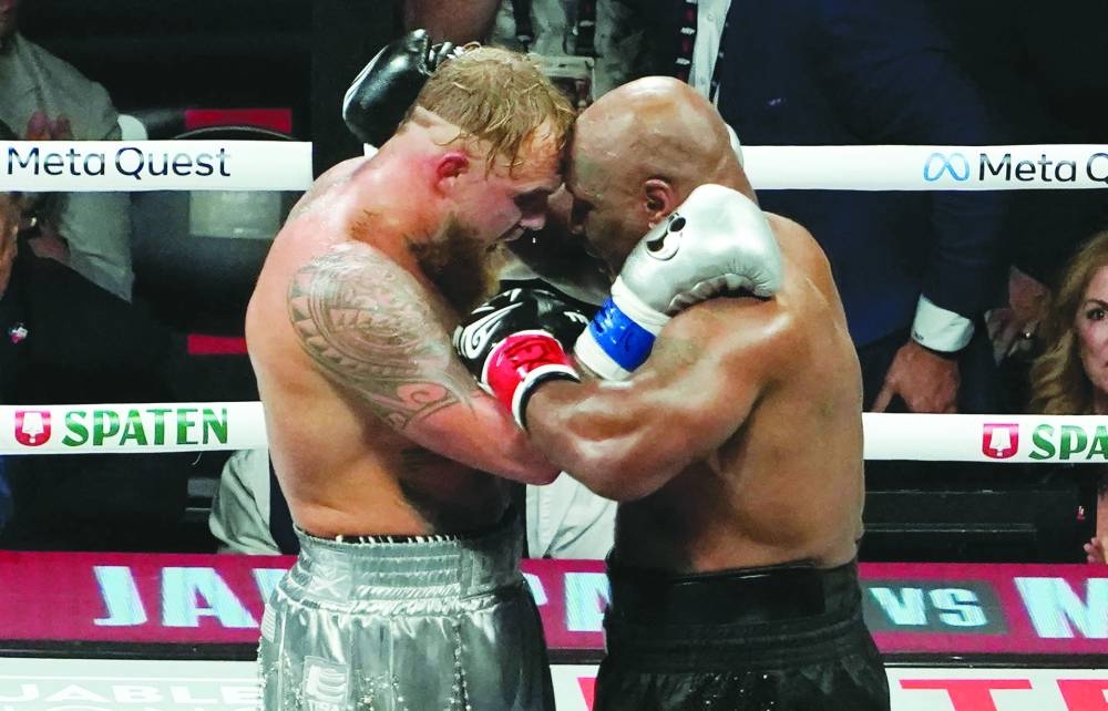 US YouTuber/boxer Jake Paul (left) and US retired pro-boxer Mike Tyson hug at the end of their heavyweight boxing bout at The Pavilion at AT&T Stadium in Arlington, Texas. (AFP)