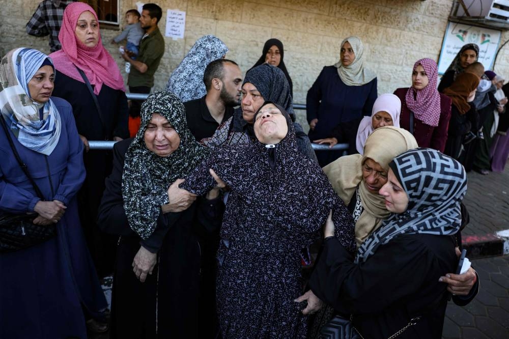 Palestinian women react in front of the bodies people killed in an Israeli strike, at the al-Aqsa Martyrs Hospital in Deir Al-Balah in the central Gaza Strip, on Sunday. AFP