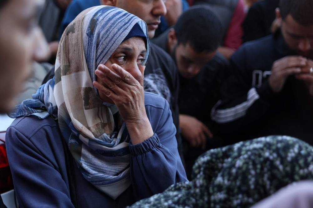 A Palestinian woman reacts in front of the bodies people killed in an Israeli strike, at the al-Aqsa Martyrs Hospital in Deir Al-Balah in the central Gaza Strip, on Sunday. AFP