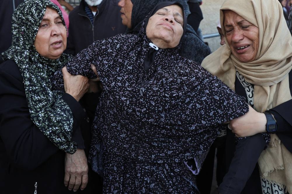 Mourners react during the funeral of Palestinians killed in an Israeli strike, at Al-Aqsa Martyrs Hospital in Deir Al-Balah, in the central Gaza Strip, on Sunday. REUTERS
